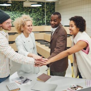 A diverse group of adults collaborating in a modern office environment, showcasing teamwork and camaraderie.