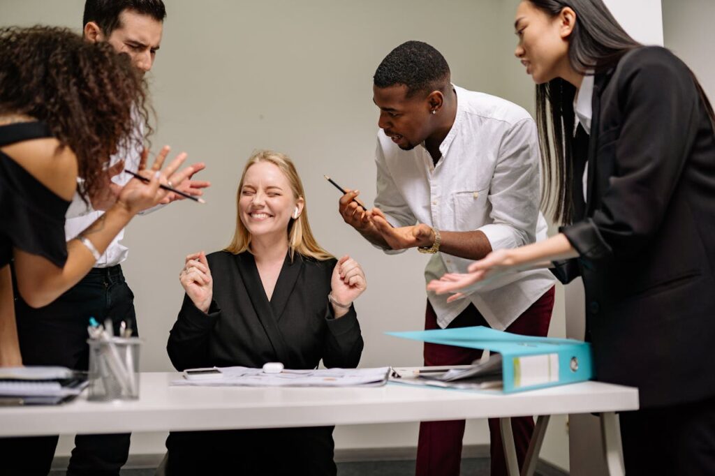 A lively and diverse team collaborates in a modern office setting. Vibrant discussion and teamwork.